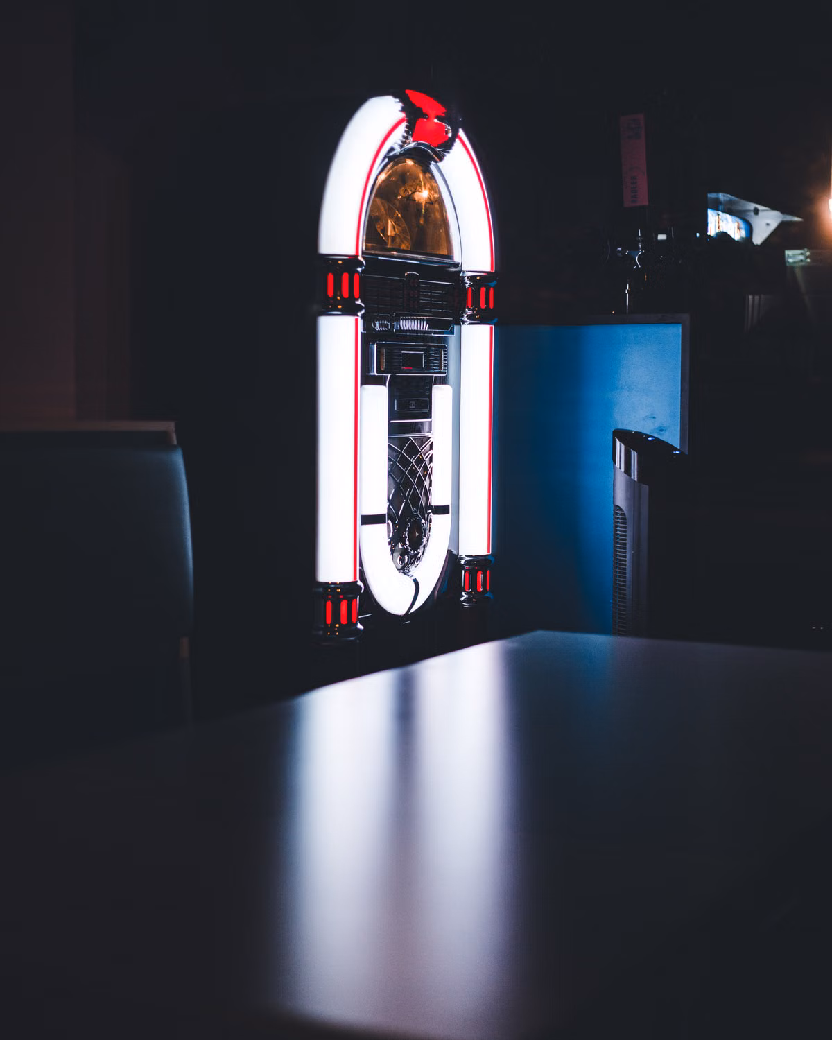 A jukebox lit up in a dark bar